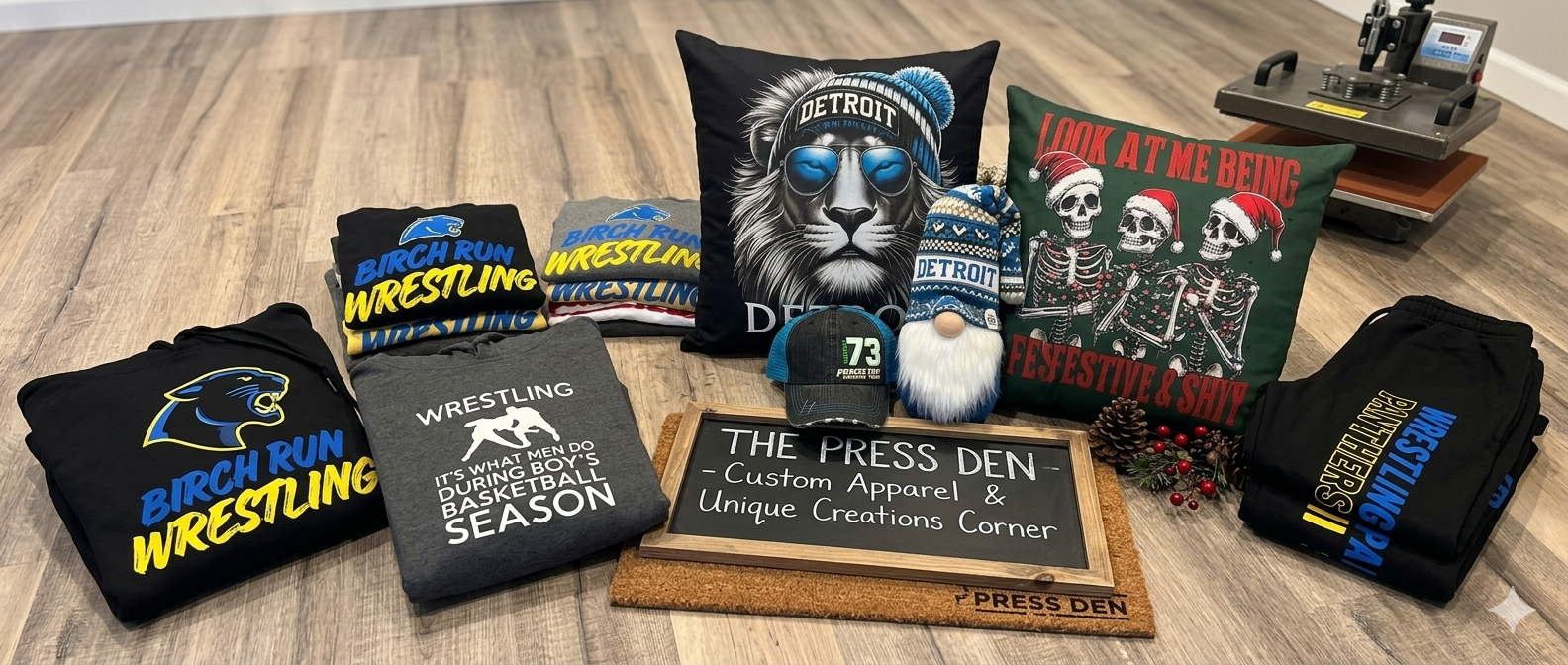 The Press Den product spread — hoodies, pillows, gnomes, hats, and more with heat press